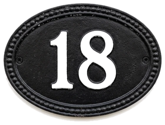 A black enamel house-number plate reading 18.